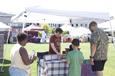 Customers looking at merchandise in a Church St Farmers Market booth