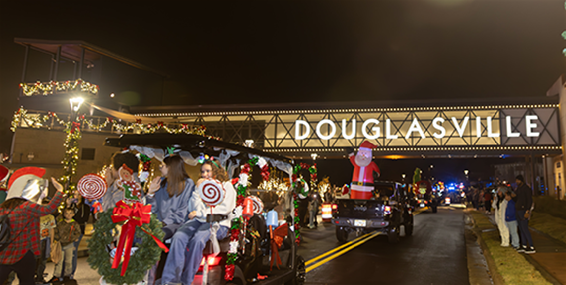 Christmas Parade floats passing under Douglasville Sign