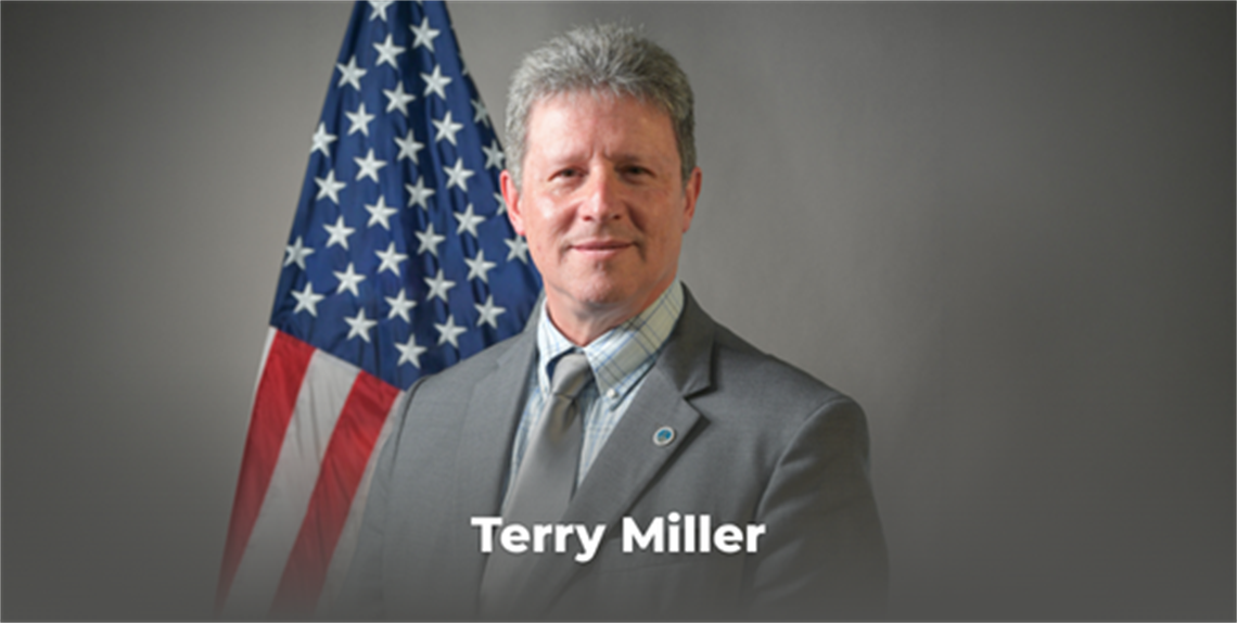 Photo of Terry Miller in front of the American Flag