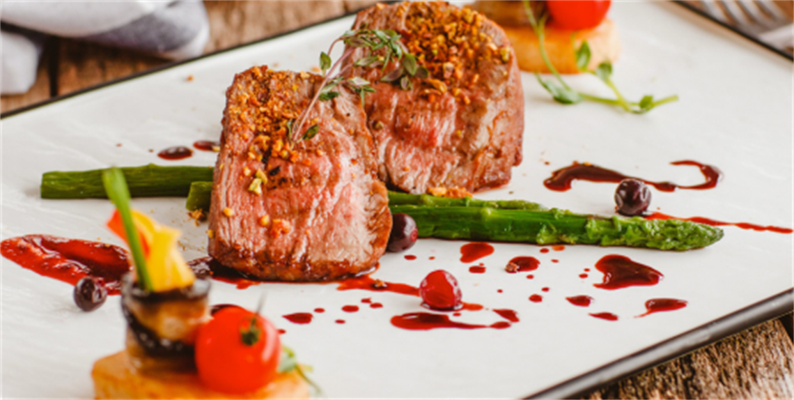 Beautifully crafted plate of medium steak medallions with asparagus