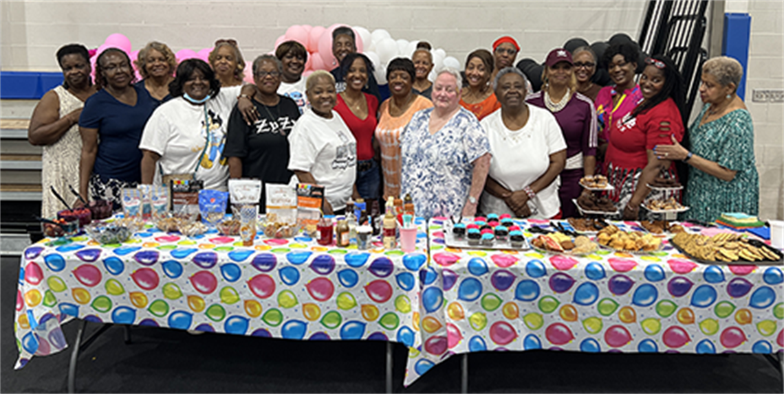 Senior adults posing behind the ice cream table